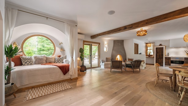 Quarto amplo com uma cama grande, área de jantar e cozinha.