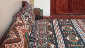 A room with a sofa, a patterned rug, a wooden wardrobe, and a small table with a lamp. - Nice Property Marrakech Village With Pools and Gardens (Marrakech)
