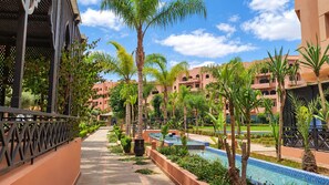 Ein Resort mit Swimmingpool, Palmen und einem überdachten Gang.