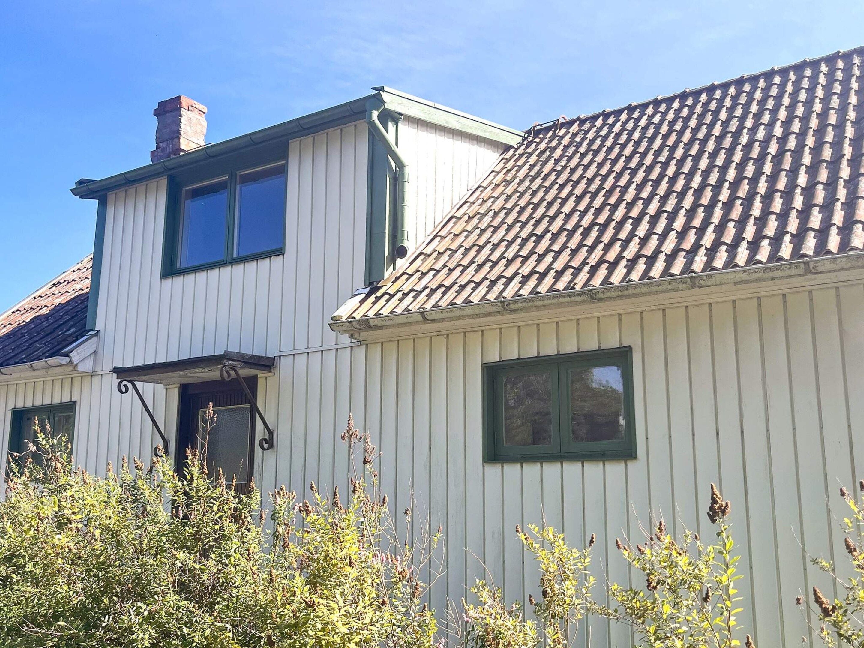 A two-story building with a tiled roof and white siding.