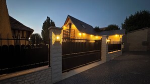 Ein durch eine Mauer und ein schmiedeeisernes Tor geschütztes Anwesen mit einer Auffahrt, die zu einer Garage führt.