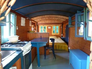 Ein kompaktes Wohnmobil-Interieur mit einer Küchenzeile, einem Bett und einer Essecke.