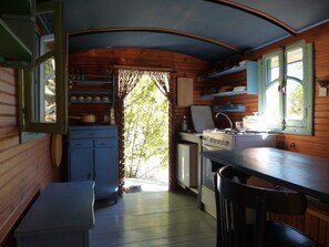 A compact kitchen with wooden cabinets, a sink, and a stove. - Veyronne caravan (Aubres)