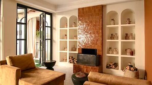 Un salon moderne avec une cheminée, des canapés et un téléviseur.