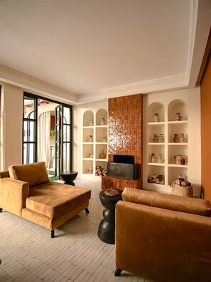 Ein modernes Wohnzimmer mit Kamin, Sofas und Fernseher.