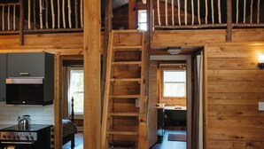 A wooden interior with a kitchen, a staircase, and a living area.