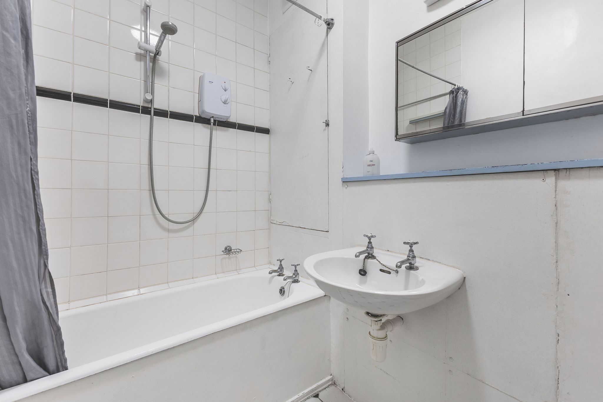 Ein Badezimmer mit einer Badewanne, einer Dusche und einem Waschbecken.