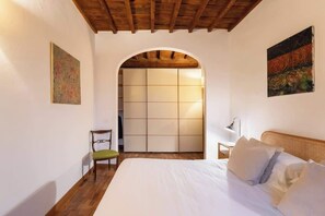 Une chambre à coucher avec un lit, une chaise, un bureau et une armoire.