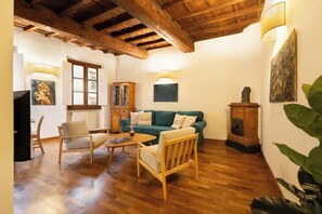 Un salon chaleureux avec un parquet en bois, un canapé vert, une table basse en bois et un meuble.