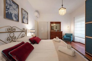 Ein Hotelzimmer mit einem Bett, einem Schminktisch, einem Sessel, einem Spiegel und Bildern an den Wänden.