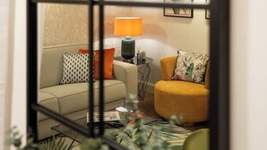 A living room with a sofa, armchair, lamp, and framed artwork. - Guelfa Spacious New Elegant Central Position (Firenze)