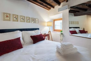 A hotel room with a bed, pillows, a lamp, a window, and framed pictures on the wall. - CS Giorgio Hidden Gem Close to Ponte Vecchio (Firenze)