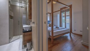 Een moderne badkamer met een douchecabine van glas en een houten wastafelmeubel.