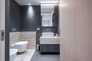 A modern bathroom with a toilet, bidet, and sink. - Solatio + Toscano assieme · Terrazza Jacuzzi in centro a Greve, 2 appartamenti (Greve in Chianti)