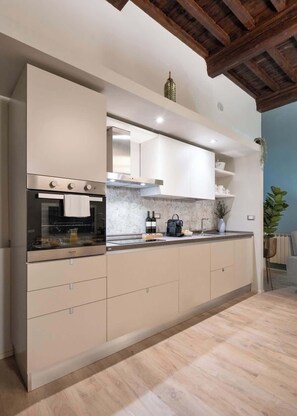 A modern kitchen with built-in appliances, a wooden ceiling, and a potted plant. - Reparata Wide Beautiful 10 min to Train Station (Firenze)