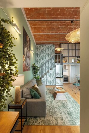 A modern living room with a sofa, a coffee table, and a staircase leading to an upper level. - Cimabue Design Loft in a Cool Area of Florence (Firenze)