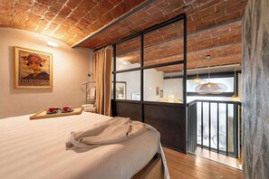 A hotel room with a large bed, a window with a view, a balcony, and a framed picture on the wall. - Cimabue Design Loft in a Cool Area of Florence (Firenze)