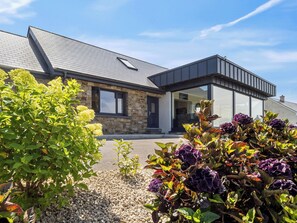 A stone house with a grey roof, a visible window, and a gravel driveway. - Brentwood/Luxury Ocean View Retreat in Connemara (Renvyle, Connemara)