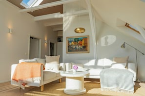 Ein modernes Wohnzimmer mit einem weißen Sofa, einem runden Couchtisch und einem Bild an der Wand.