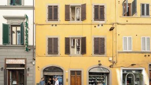 A yellow building with multiple storefronts, including a visible sign for 'Cantina Barbaglione.' - Egidio Spacious and bright 300mt from the Duomo (Firenze)