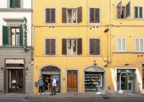 A yellow building with multiple storefronts, including a visible sign for 'Cantina Barbaglione.' - Egidio Spacious and bright 300mt from the Duomo (Firenze)