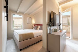 Ein Schlafzimmer mit Bett, Nachttisch, Spiegel und Fenster.