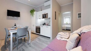 Eine moderne Wohnung mit Essbereich, Küchenzeile und Wohnzimmer mit Sofa.