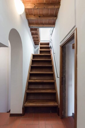A wooden staircase leading to an upper floor, with a light fixture above and a door at the bottom. - Pilastri Lorenz Rooftop with 2 Terraces Duomo View (Firenze)