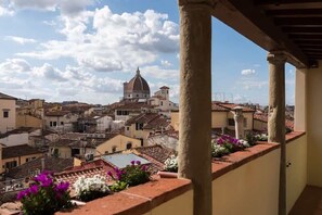 Un balcón con vistas a un pueblo histórico, que incluye una imponente estructura con cúpula.