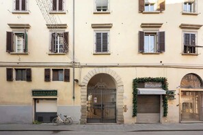 Ein Gebäude mit einer Schaufensterfassade mit der Aufschrift 'ROSTICCERIA SPECIALITA' TURCHE, einem Fahrrad davor und einer Eingangstür mit einem Schild.