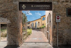 A stone archway leading to a building labeled 'IL CONVENTINO FUORI LE MURA' with a no entry sign nearby. - Giano - Conventino Modern - Apt con Garage (Firenze)