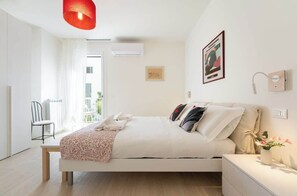 A modern bedroom with a bed, bedside table, and a window with curtains. - Giano - Conventino Modern - Apt con Garage (Firenze)