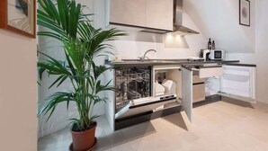 Eine moderne Küche mit Geschirrspüler, Mikrowelle und einem Blumentopf.