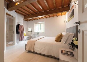 A bedroom with a bed, a window, a radiator, and a door leading to a bathroom. - Casa Falorni, 3 a+b - Pia e Simonetta - Trilocale (Greve in Chianti)