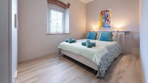 A bedroom with a bed, a window, a painting, and a light fixture. - Civette 1, Studio Apt with Shared Garden View (Greve in Chianti)