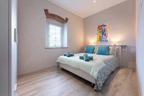 A bedroom with a bed, a window, a painting, and a light fixture. - Civette 1, Studio Apt with Shared Garden View (Greve in Chianti)