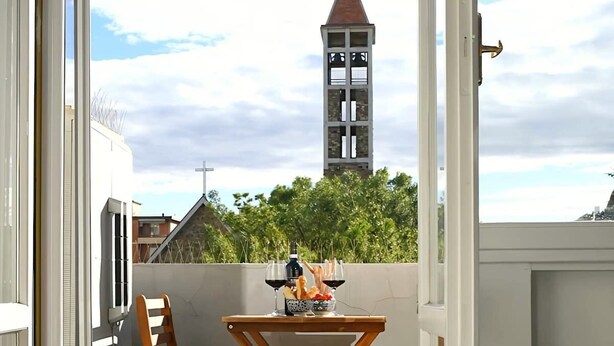 Ein Balkon mit Tisch, Stühlen und einer Kerze.