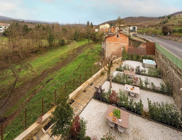 Ein Wohnhaus mit Garten, Terrasse und Blick auf die umliegende Landschaft.