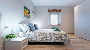 A bedroom with a bed, nightstand, and a window with a view. - Civette 3, Apt 2 Bedrooms in Greve in Chianti (Greve in Chianti)