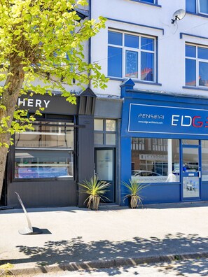 Ein Gebäude mit einer Schaufensterfront, auf der 'HERY' und ein weiteres mit 'EDGE Architects' steht.