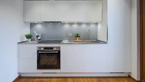 A modern kitchen with white cabinetry, a built-in oven, and a stainless steel countertop. - Il toscano - Nuovo con terrazza in centro a Greve (Greve in Chianti)