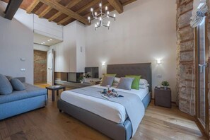 Una camera da letto con un letto, comodini, una televisione e un soffitto in legno.