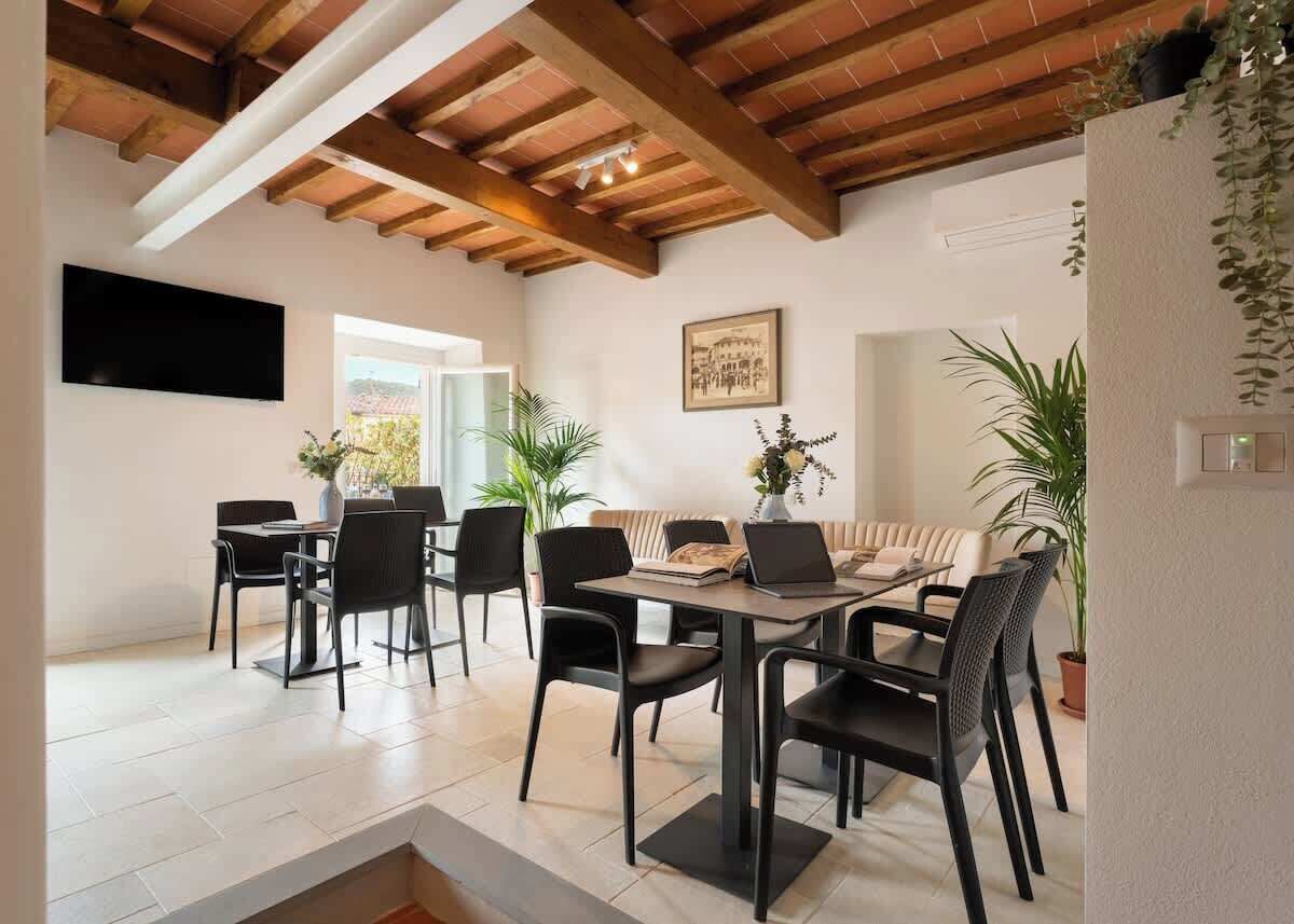 Un comedor con una mesa, sillas y plantas en macetas.