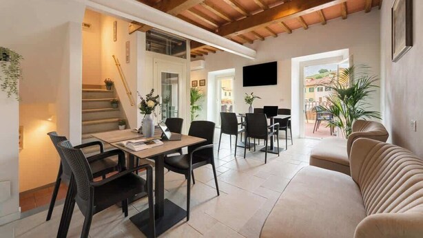 A modern interior with a dining area, sofa, and staircase. - Casa Falorni, 1 - Raffaello - Bilocale (Greve in Chianti)