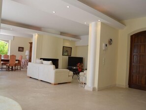 A spacious living area with a sofa, television, and a dining table. - Neo-Provencal villa with sea view (Vallauris)