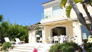 Un bâtiment à deux étages doté d’un balcon, d’un espace extérieur aménagé pour s’asseoir et d’une piscine.