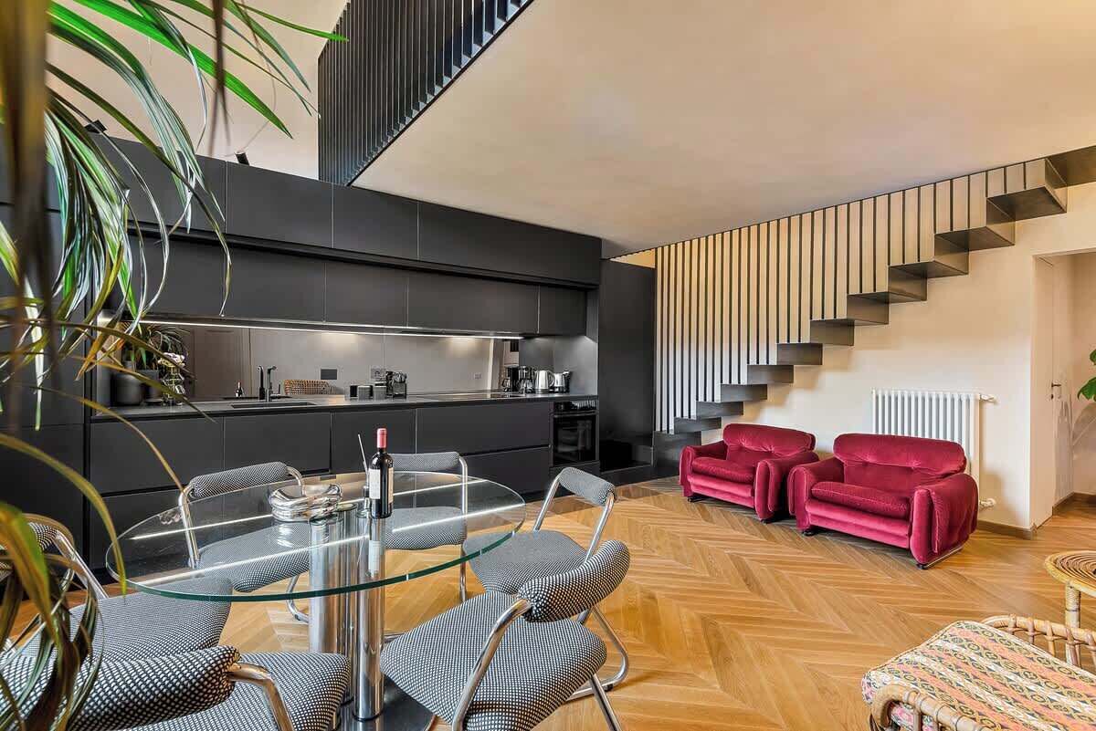 Ein modernes Interieur mit Essbereich, Küche und Treppe.