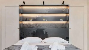 Ein Bett mit Kopfteil, Kissen und zusammengerollten Handtüchern.