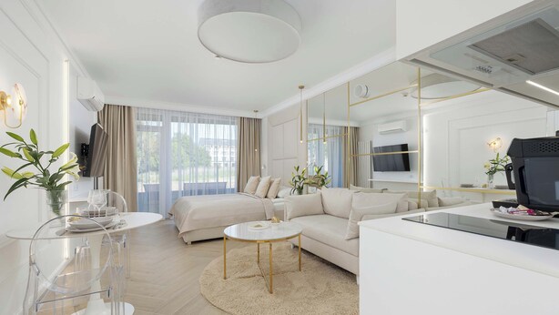 A modern living room with a sofa, a coffee table, and a TV. - Elegant Studio with Terrace, Close to the Sea by Noclegi Renters (Ustronie Morskie)