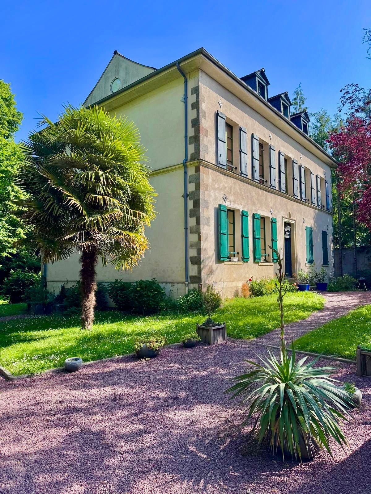 Un edificio de dos plantas con un jardín delantero.